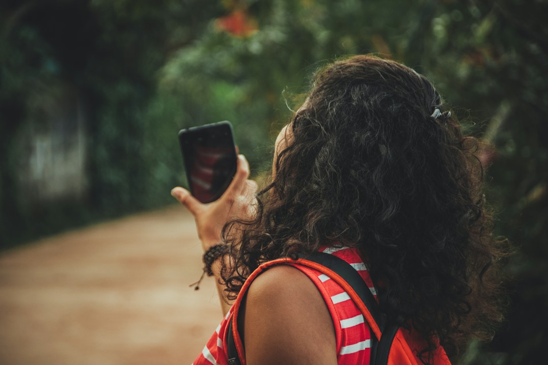 Person using a phone and laptop with personal data